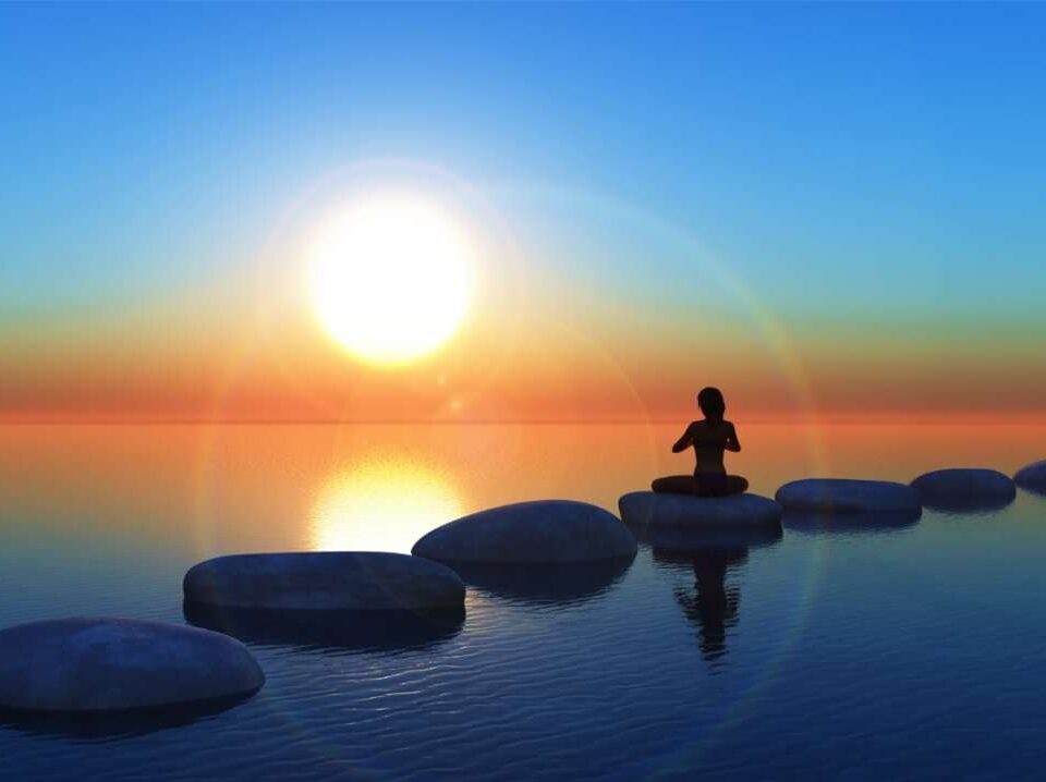 A person practicing meditation near a serene water body, embracing tranquility and inner peace